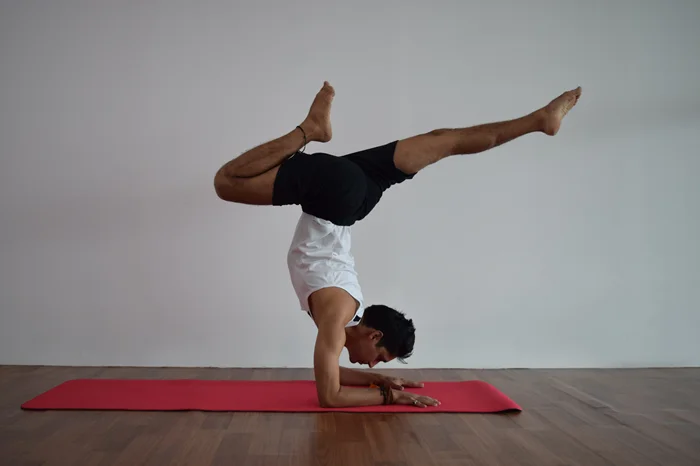 yoga teacher doing hand stand yoga pose